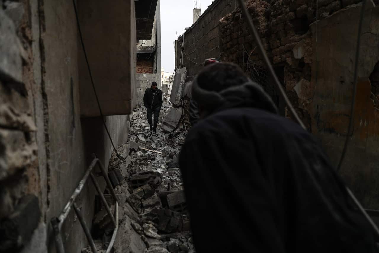 People walk on a destroyed street in the aftermath of airstrikes on Mesraba, eastern Ghouta.