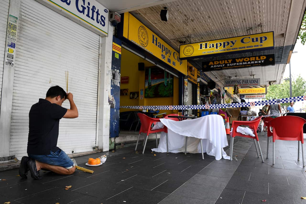 A man pays his respects at the scene of a shooting at a cafe at Bankstown City Plaza, in Bankstown. 