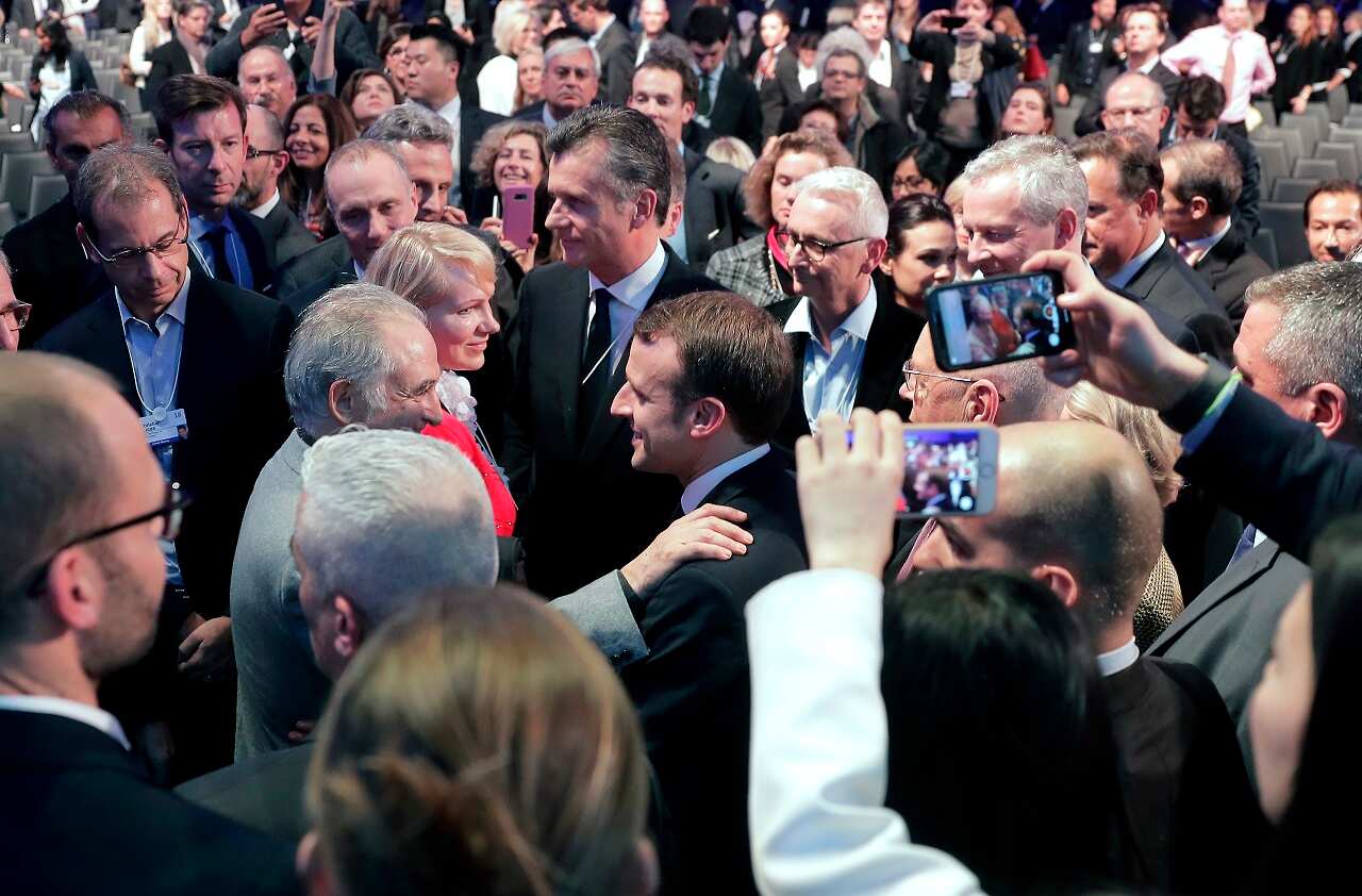 Emmanuel Macron, President of France, center, is surrounded by listeners after a special address as part of the annual meeting of the World Economic Forum in Davos, Switzerland.