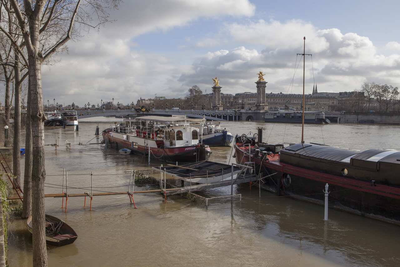 Barges moored along the swollen Seine River in Paris.