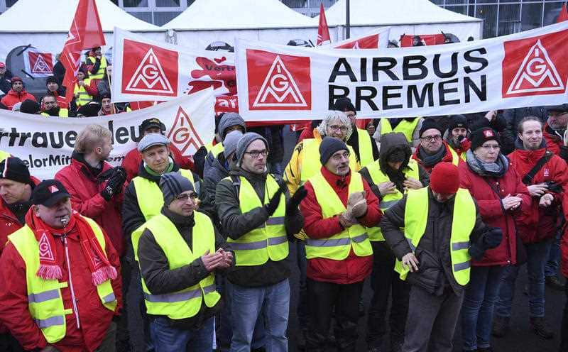 Airbus employees gather in front of the company in Bremen, northern Germany, during a strike in Bremen, Germany, Friday, February 2, 2018.