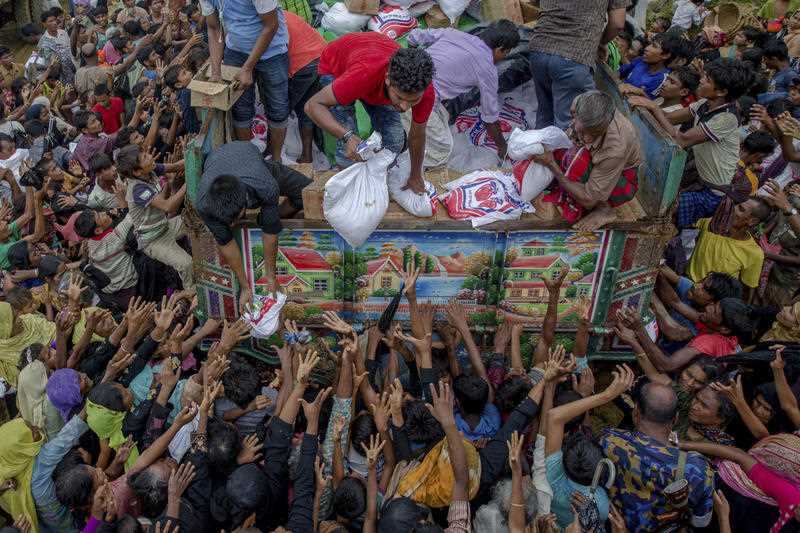 In this Monday, Sept. 18, 2017, file photo, Rohingya Muslims, who crossed over from Myanmar into Bangladesh, reach out for food distributed by aid agencies near the Balukhali refugee camp in Cox's Bazar, Bangladesh.
