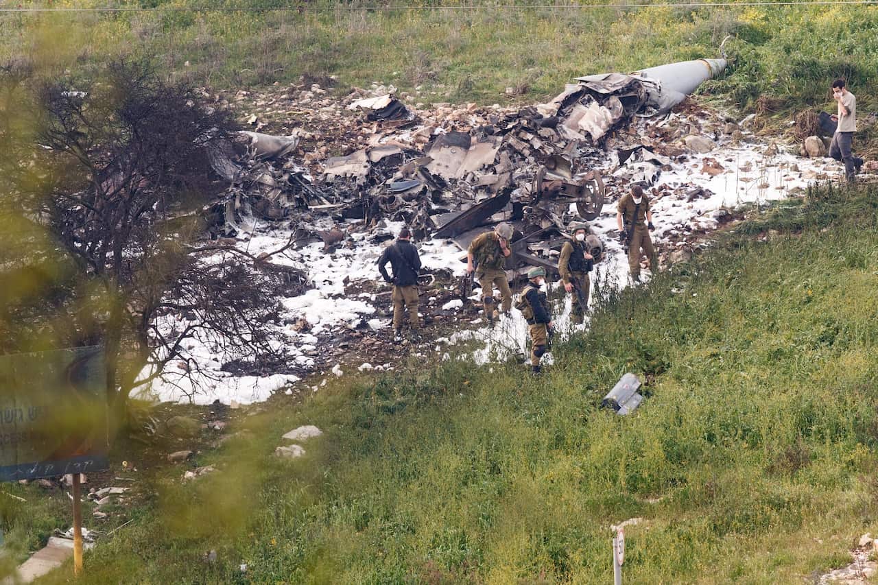 Israeli soldiers inspect the remains of an F-16 that crashed in northern Israel.
