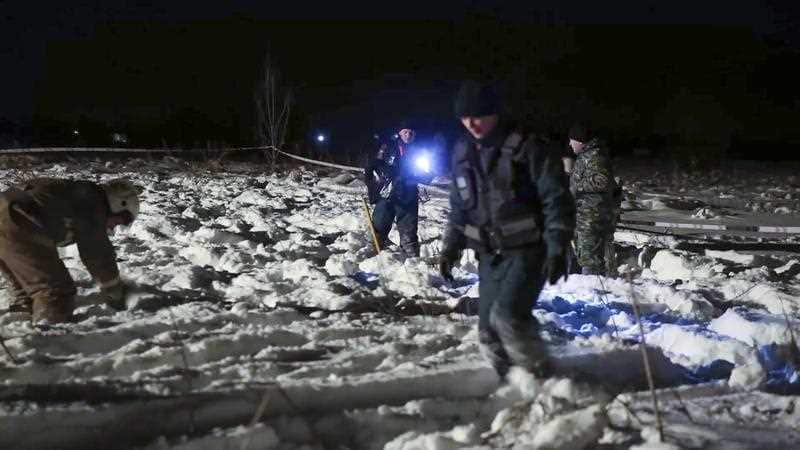 In this photo provided by the Russian Emergency Situations Ministry, RMES employees work at the scene of a AN-148 plane crash in Stepanovskoye village.