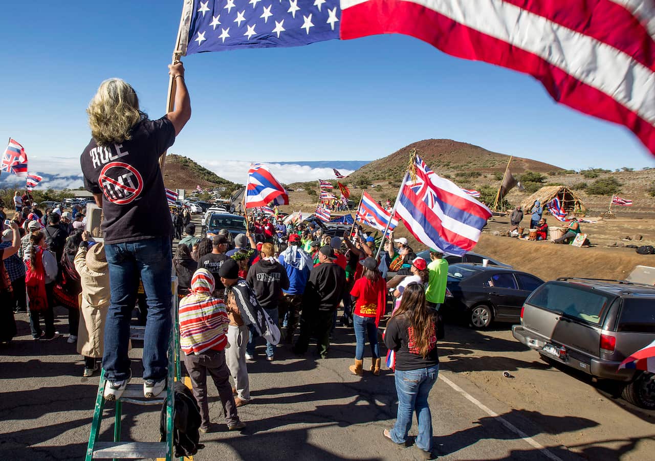 In this June 24, 2015 file photo, Thirty Meter Telescope protesters walk on a road during a blockade that prevented TMT construction vehicles from driving up to the summit of Mauna Kea.