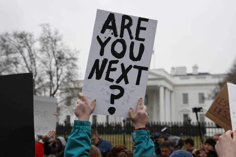 Demonstrators hold signs during a protest in favor of gun control reform in front of the White House, Monday, Feb. 19, 2018, in Washington. 