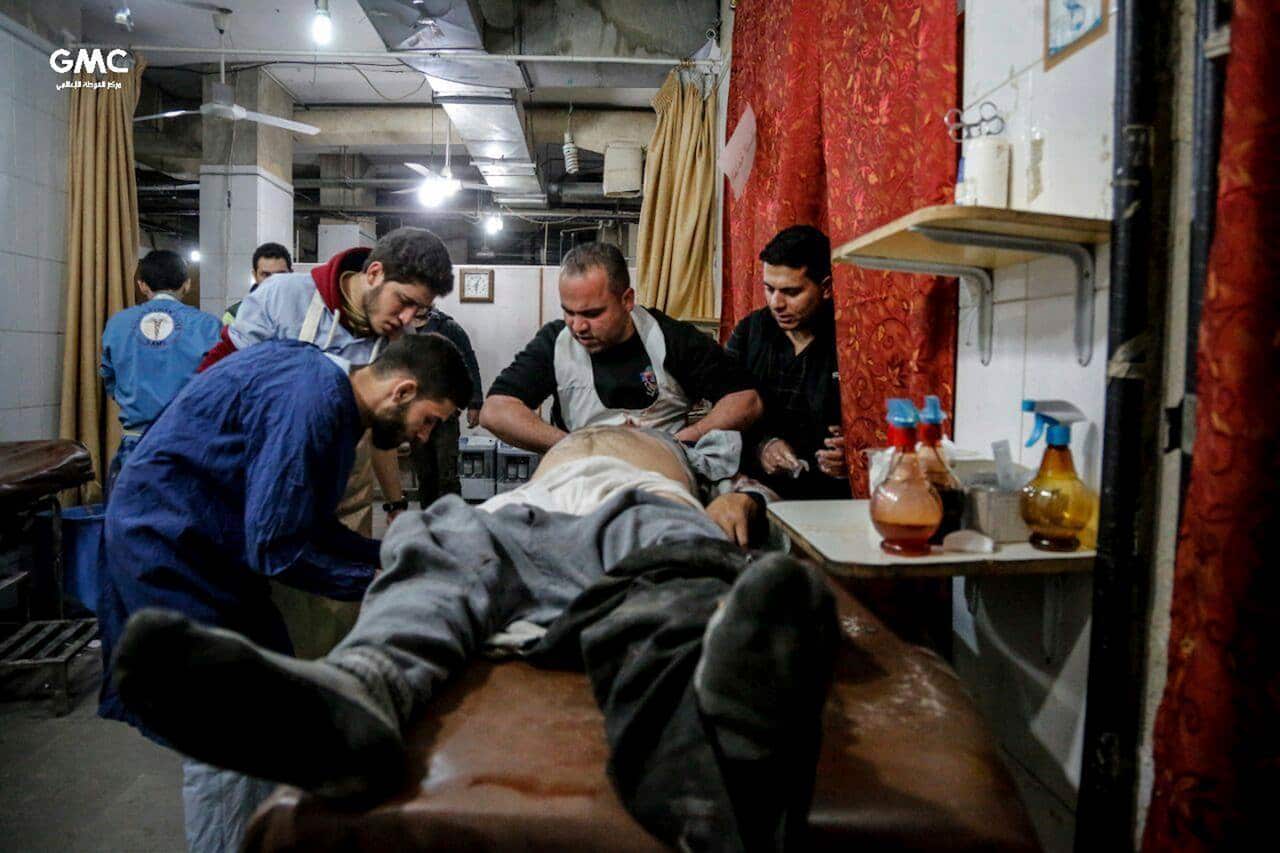 Syrian paramedics treat an injured man who was wounded by the shelling of the Syrian government forces, at a makeshift hospital, in Ghouta.