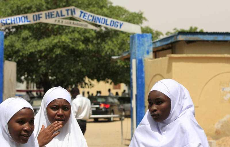 In this Thursday, June. 6, 2013 file photo, Young women stand in front of a school in Maiduguri, Nigeria.
