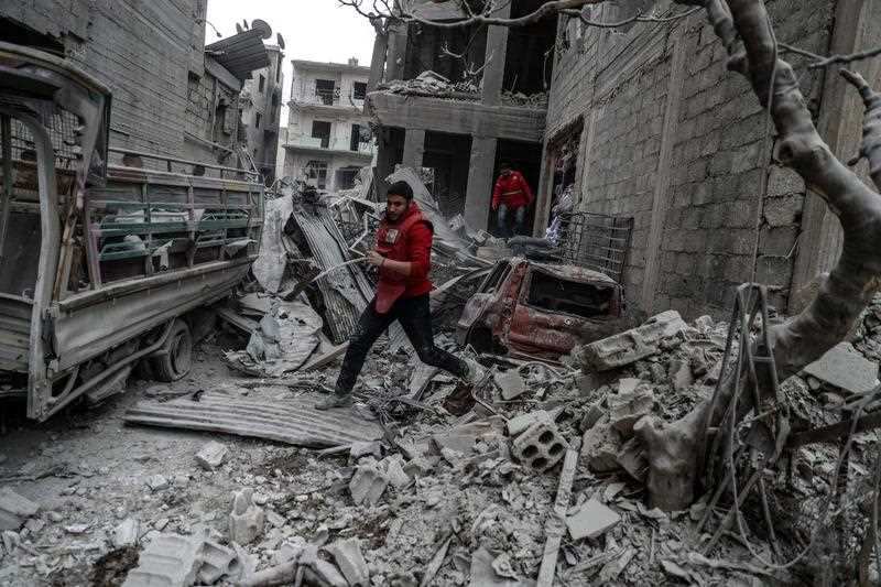 A red crescent volunteer runs after bombing, rebels-held Douma, Eastern Ghouta, Syria, 22 February 2018.