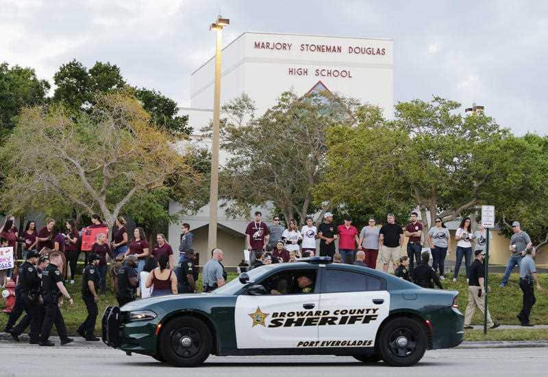 A police car drives by Marjory Stoneman Douglas High School in Parkland, Fla., Wednesday, February 28, 2018.