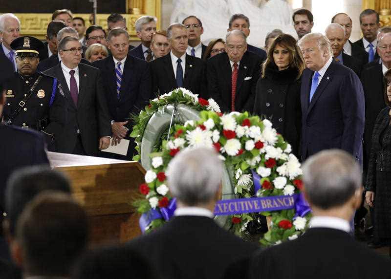 President Donald Trump and First Lady Melania Trump pay their respects at the casket together as the late evangelist Billy Graham lies in honour.