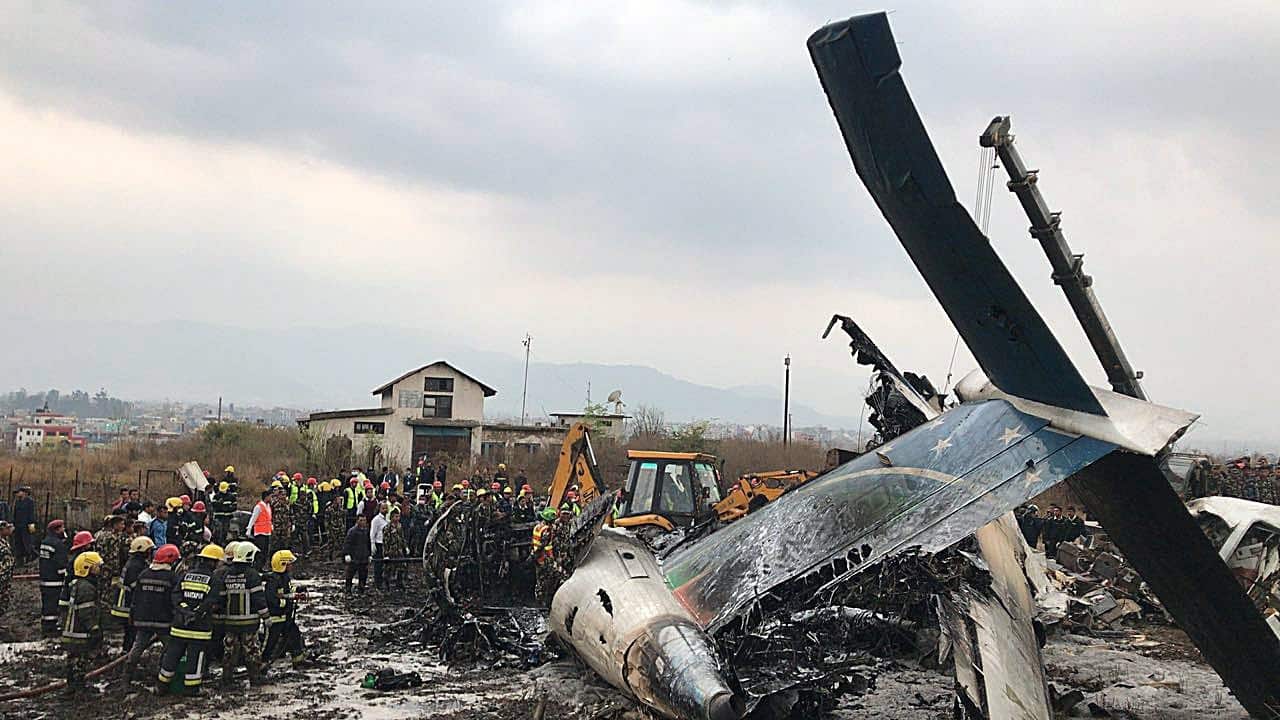 Rescue teams next to a wreckage of a plane that crashed at the main airport Tribhuvan International Airport in Kathmandu, Nepal.