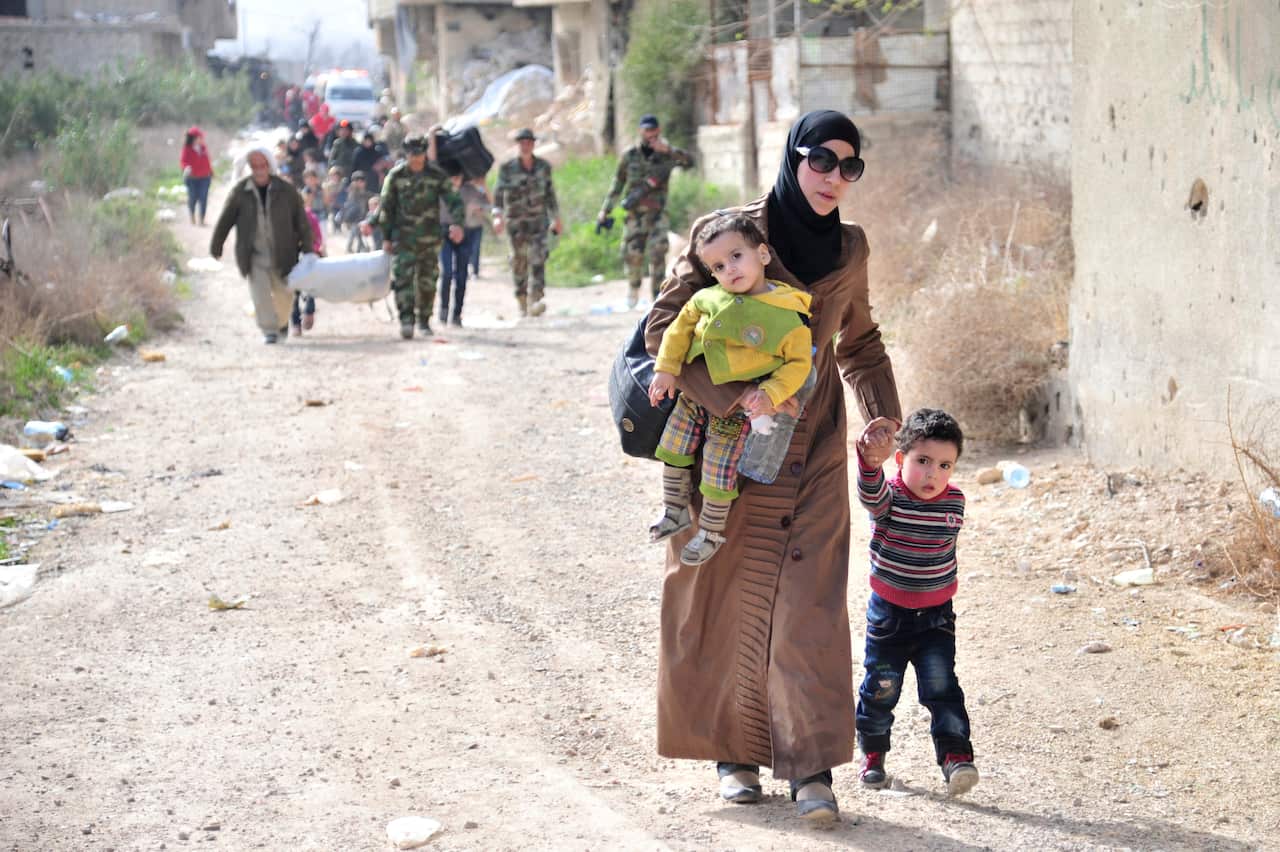 Civilians who fleeing from fighting between the Syrian government forces and insurgents pictured at a crossing in Ghouta