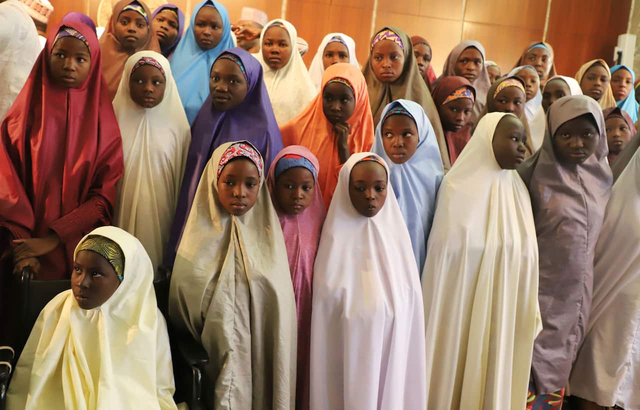 Recently freed School girls from the Government Girls Science and Technical College Dapchi, pose for a photograph after a meeting with Nigeria President.