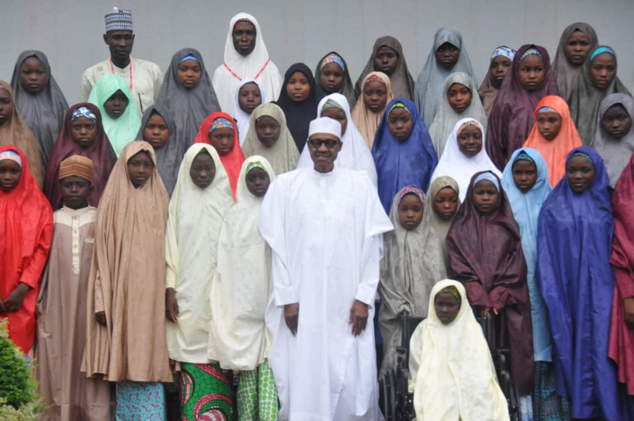 President Muhammadu Buhari (C) poses for photographs with the released Dapchi School Girls who were abducted by Boko Haram.