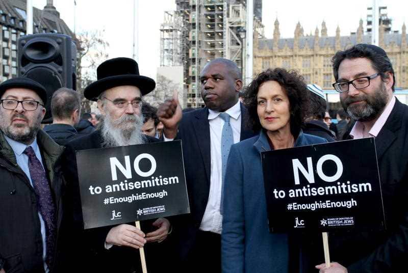 People hold up a sign as a demonstration against anti-Semitism 
