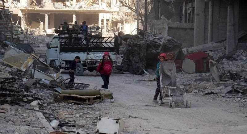 Children walk through the rubbles of damaged buildings in the recently-liberated Harasta City in the Eastern Ghouta in the countryside of Damascus, Syria.