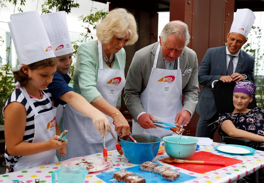 The Prince of Wales and the Duchess of Cornwall participate in a cooking activity during a visit to the Lady Cilento Children's Hospital.