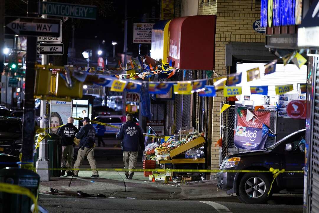 Investigators look over the scene where officers shot and killed a man in Brooklyn.