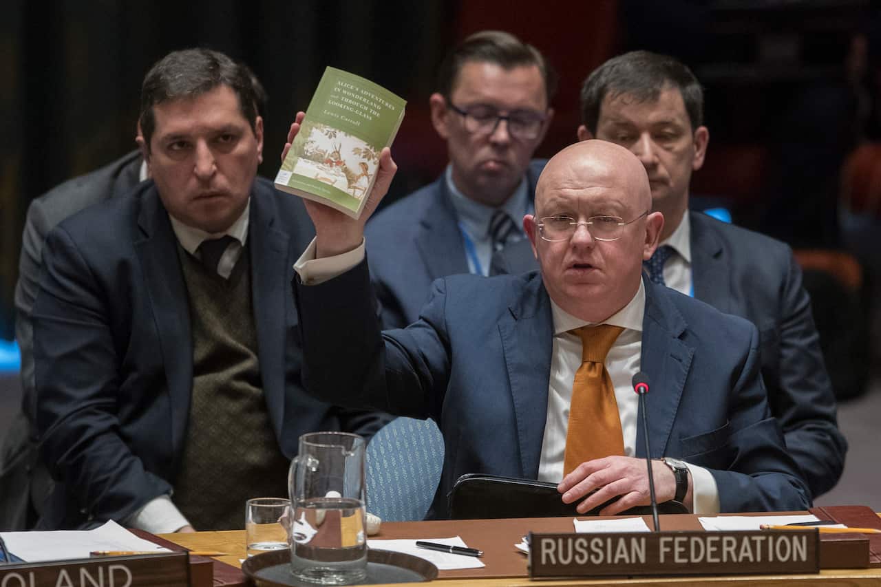 Russian Ambassador to the UN, Vassily Nebenzia, holds up a copy of "Alice's Adventures in Wonderland" as he speaks during a Security Council meeting.