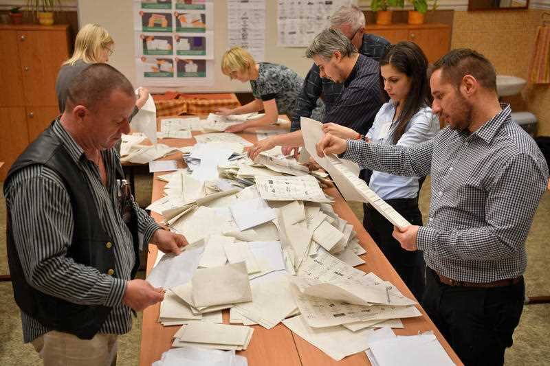 Members of the local election committee check ballots at a polling station during the general election in Debrecen, Hungary, Sunday, April 8, 2018. 