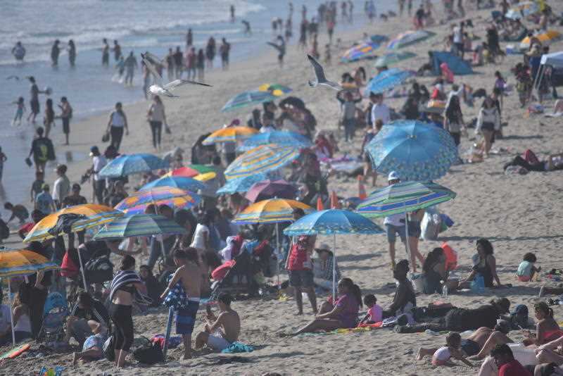 United States, California:Crowds form on the beach as a heat wave descends over Santa Monica Pier in Los Angeles, California on April 10, 2018.