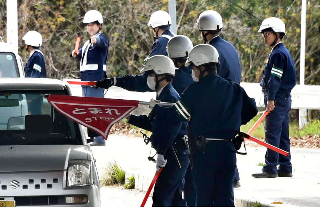 Police officers inspect cars at a checkpoint in Onomichi, Hiroshima prefecture.