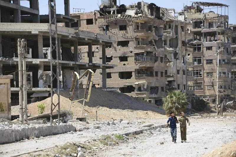 Children walk in a devastated area of Douma in Eastern Ghouta, Syria, on April 16, 2018, where chemical weapons were suspected to have been used against citizens. 