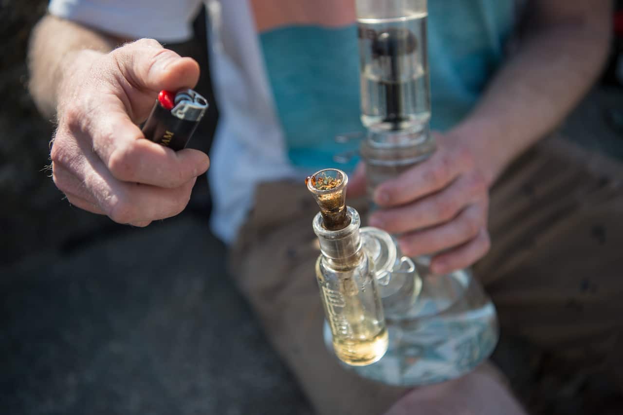 A man smokes a bong with medical cannabis during a protest.