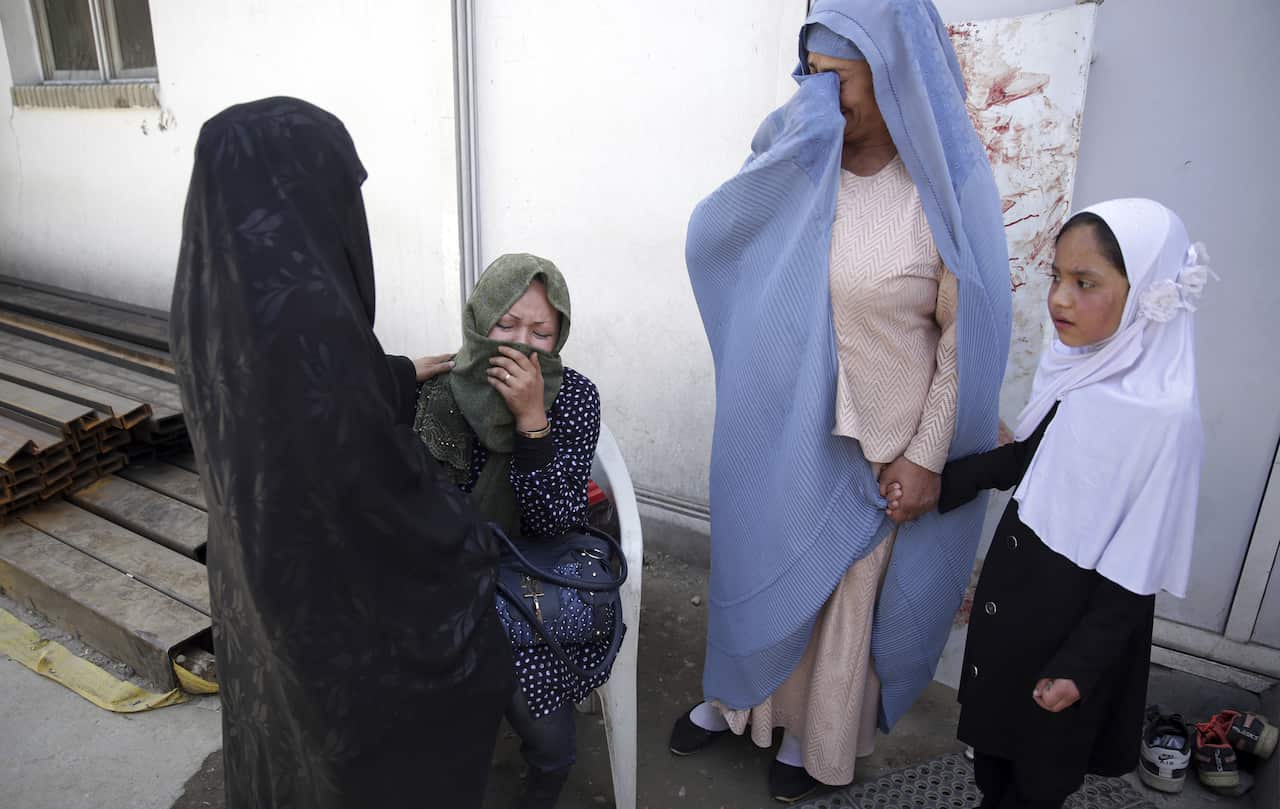 Women cry in a hospital after they lost their children in a deadly suicide attack on a voter registration center in Kabul.
