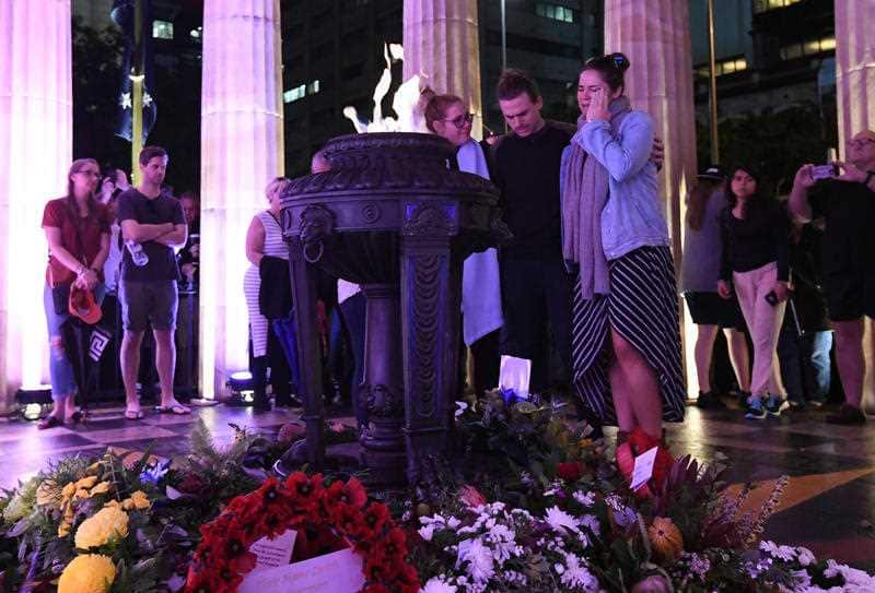 A family grieves during Anzac Day commemorations in Brisbane, Wednesday, April 25, 2018.