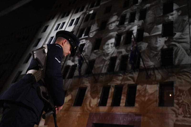 A image showing soldiers is projected on a building during the Anzac Day Dawn service at Martin Place in Sydney, Wednesday, April 25, 2018.