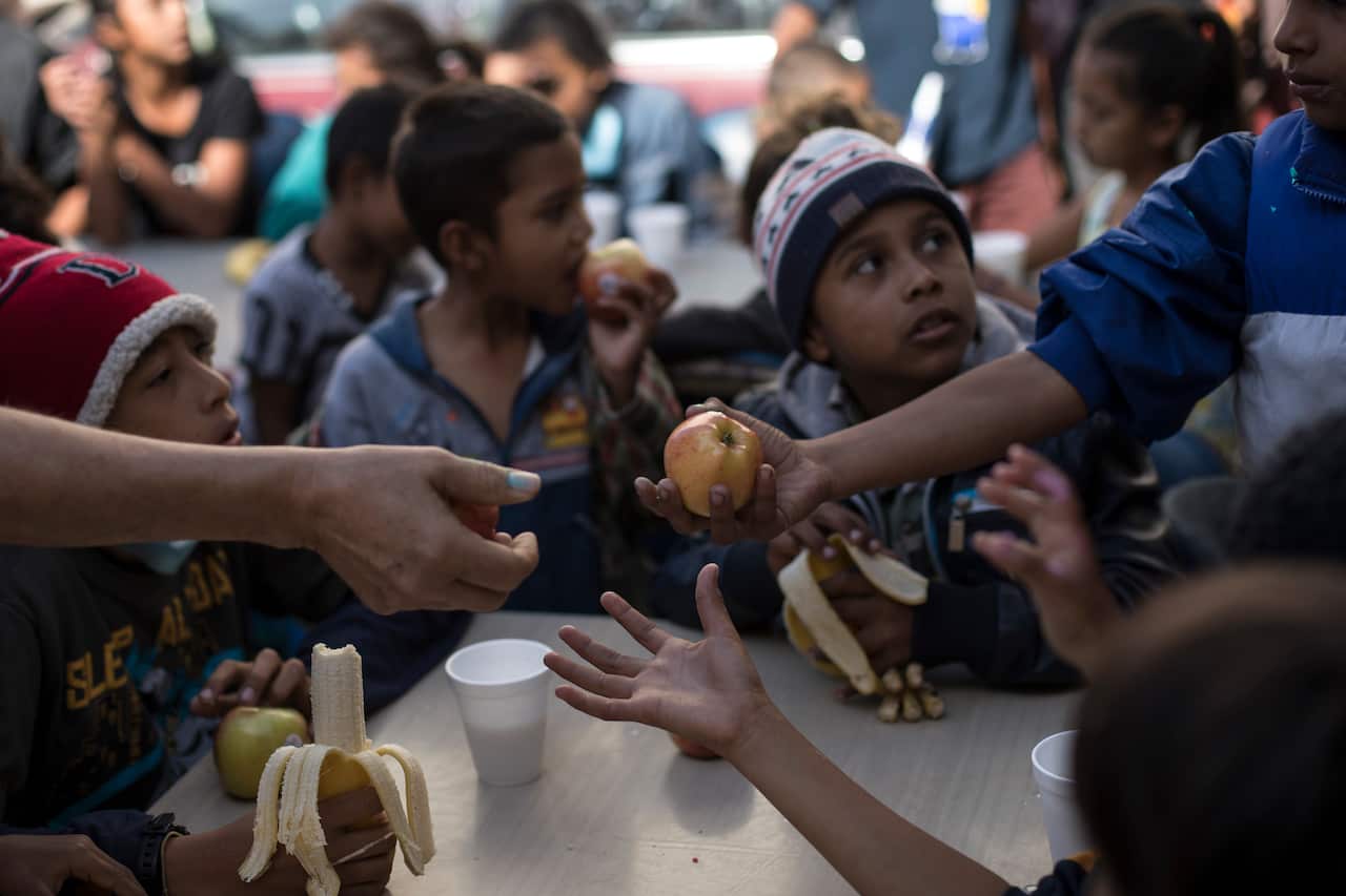 Children have their breakfast at a migrant shelter in Tijuana, Mexico, Saturday, April 28, 2018.
