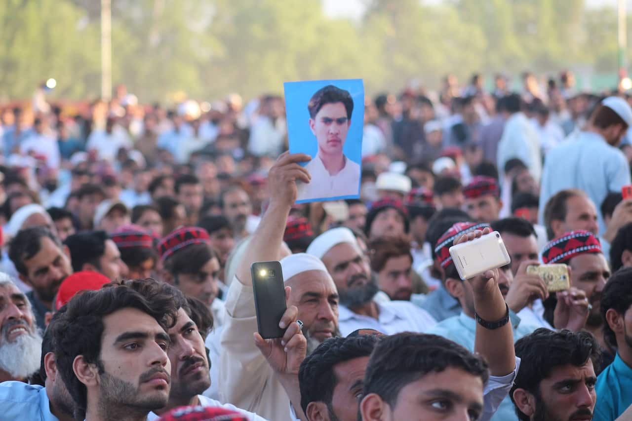 Supporters of Manzoor Pashteen, leader of the PTM, hold pictures of their missing relatives as they listen to his speech during a gathering in Swat.