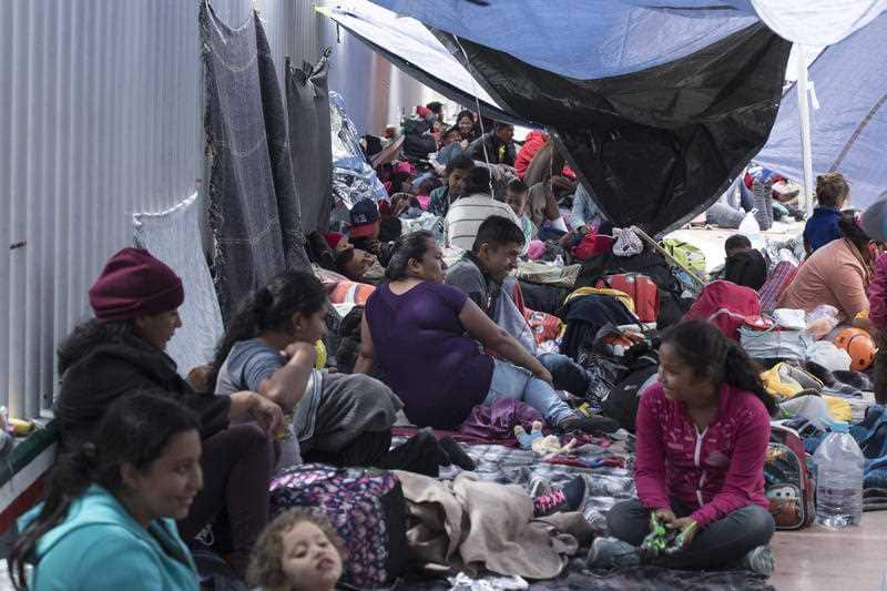 People who travelled with the annual caravan of Central American migrants wait to cross the border to request asylum in the US.