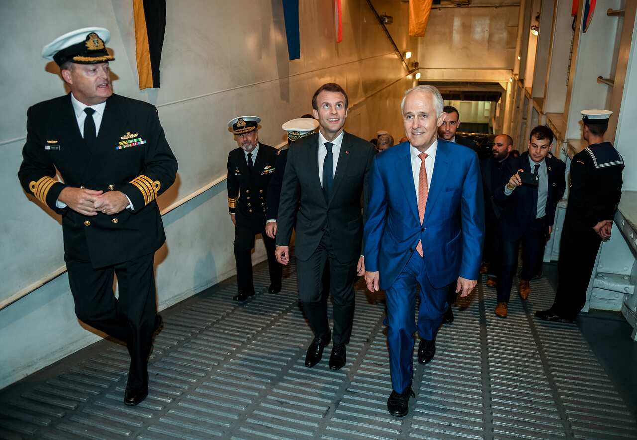 Former prime minister Malcolm Turnbull (centre right) and President of France Emmanuel Macron (centre left) on board the HMAS Canberra in 2018. (AAP)