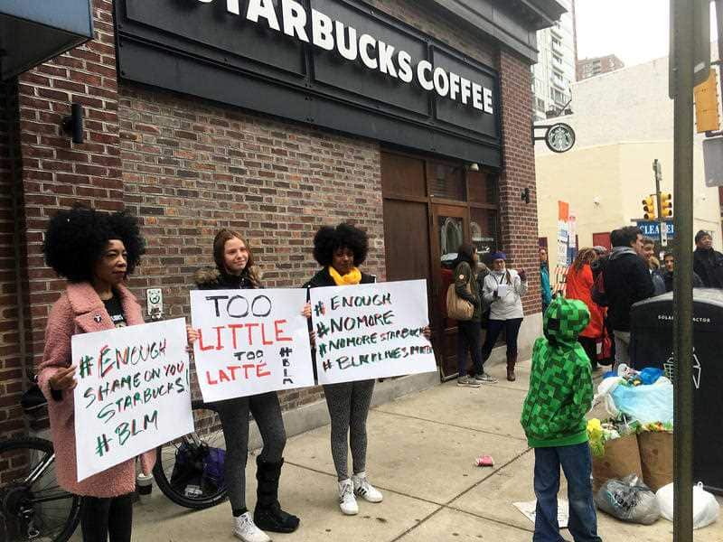 Demonstrators protest after two black men were arrested April 12, 2018, for sitting at a Starbucks cafe without ordering anything.