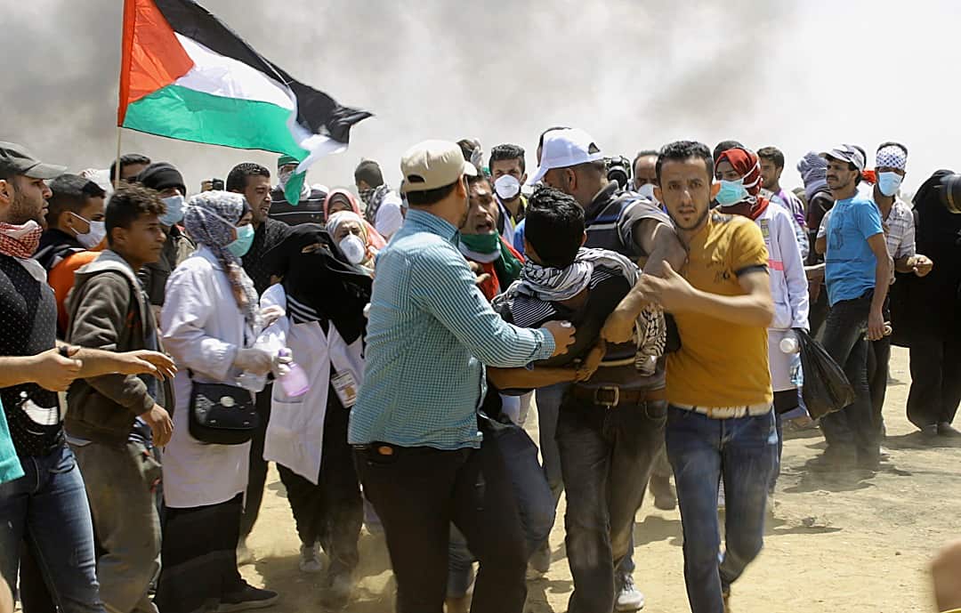 Palestinian protesters evacuate a wounded youth.
