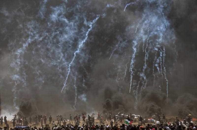 Israeli troops fire tear-gas at Palestinian protesters during clashes after protests near the border with Israel in the east of Jabaliya in the northern Gaza Strip, 14 May 2018.
