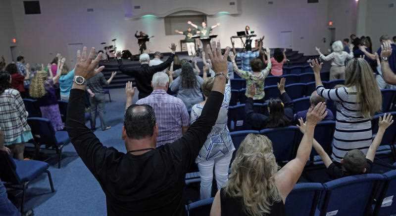 Members of the Dayspring Church raise their hands in prayer Sunday, May 20, 2018, in Santa Fe, Texas.