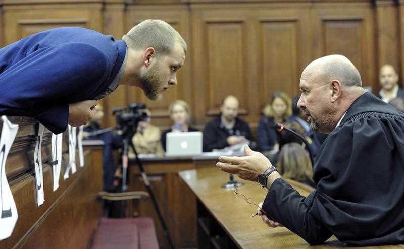 Henri van Breda, left, talks to one of his legal adviser, Piet Botha, right, in the HIgh Court in Cape Town, South Africa, Monday, May 21, 2018.