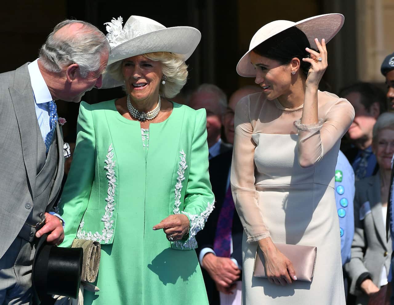 The Prince of Wales and the Duchess of Cornwall with the Duchess of Sussex (right) at a garden party at Buckingham Palace in London