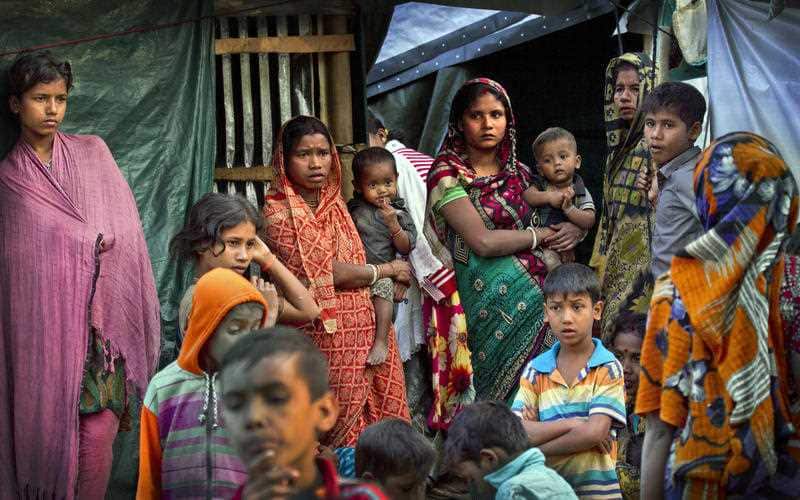 Rohingya Hindu refugees stand outside their make shift shelters at Kutupalong refugee camp, Bangladesh, Tuesday, Jan. 16, 2018.