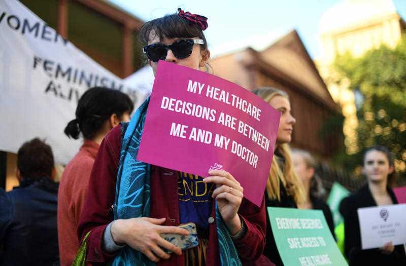 Demonstrators in favour of safe buffer-zones around NSW abortion clinics stand outside the NSW State Parliament building in Sydney, Thursday, May 24.