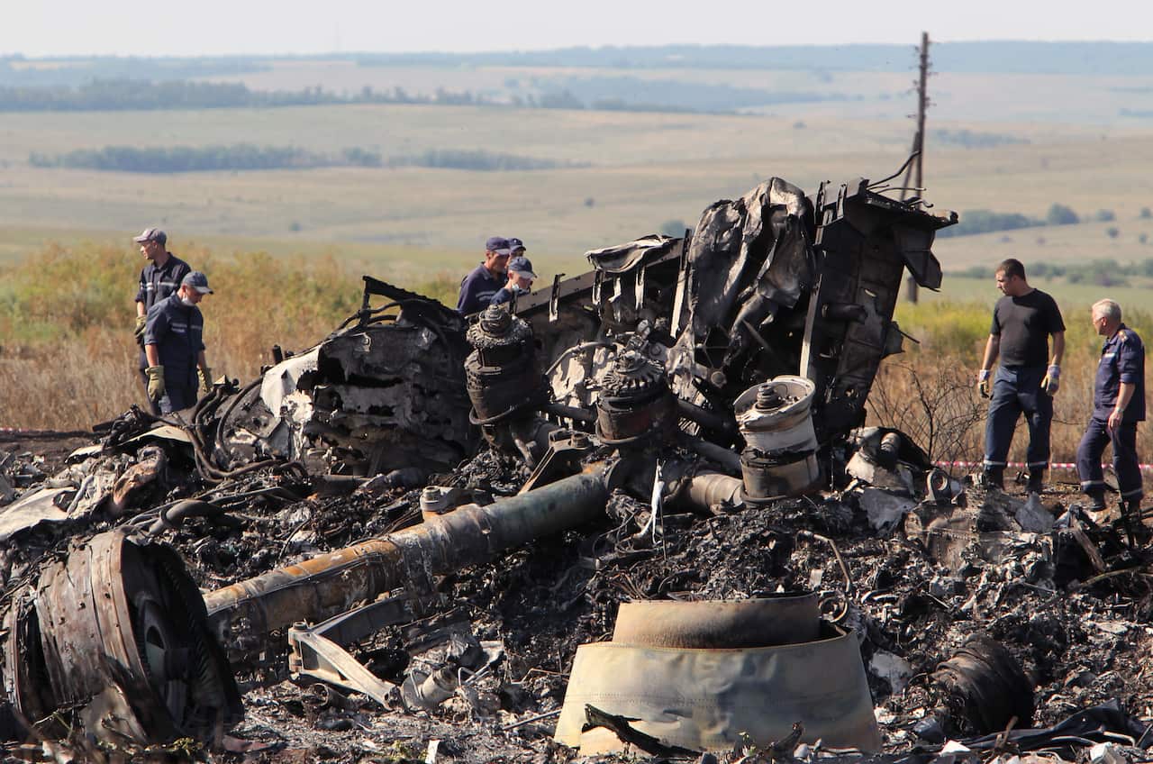 Ukrainian workers inspect debris at the main crash site of the Boeing 777 Malaysia Airlines flight MH17, which crashed over Ukraine in 2014.