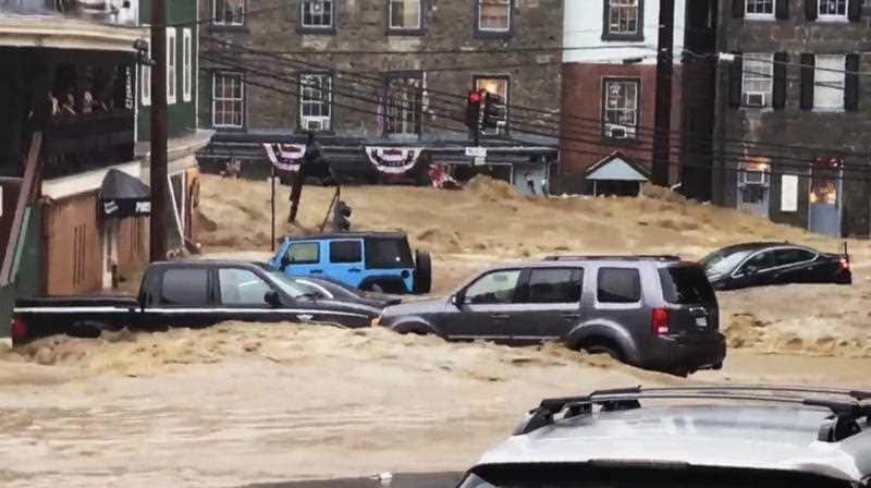 Water rushes through Main Street in Ellicott City, Md., Sunday, May 27, 2018.