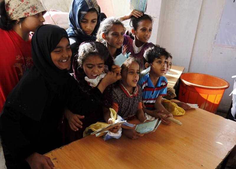 Conflict-affected Yemenis children wait to receive free food rations provided by a charity, in Sana'a, Yemen, 01 June 2018. 