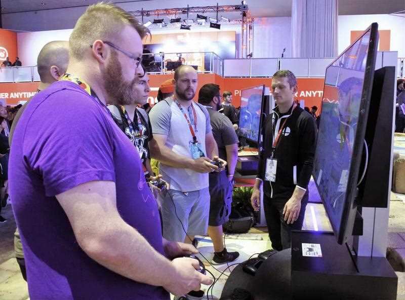 Visitors play video games on June 12, 2018, at a Nintendo of America Inc. booth at E3, a large-scale computer and video game event held in Los Angeles.