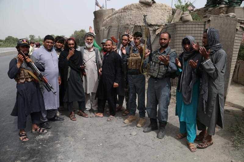 Alleged Taliban militants pose for a photograph with Afghan Police as a goodwill gesture amid the three-day ceasefire.