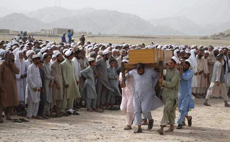People attend the funeral of the victims who were killed a day earlier in a suicide bomb attack in Rodat district.